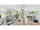 Bright living room featuring gray couches, wood floors, and a large TV at 2575 Shenandoah St, North Port, FL 34287