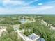 Expansive aerial view showcasing the community with lush greenery, lake, and golf course at 5062 Elm Leaf Dr, Brooksville, FL 34601
