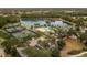 Aerial view of community pool, tennis courts, and lake at 5062 Elm Leaf Dr, Brooksville, FL 34601