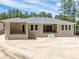 Back of the home showcasing a covered patio, stairs leading to the yard, and multiple windows at 5062 Elm Leaf Dr, Brooksville, FL 34601