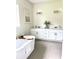 Double vanity bathroom with a soaking tub and neutral tile flooring at 5062 Elm Leaf Dr, Brooksville, FL 34601