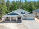 Stunning single-Gathering home boasting a three-car garage and charming front porch with stone pillars at 5062 Elm Leaf Dr, Brooksville, FL 34601