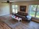 Bright living room featuring wood floors, a plaid couch, and large windows overlooking a well-maintained lawn at 9157 42Nd N Way, Pinellas Park, FL 33782
