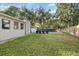 Backyard featuring a spacious green lawn, privacy fence, and pool with lounge chairs at 1504 E Mcberry St, Tampa, FL 33610