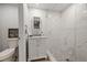 Updated bathroom featuring a marble shower, white vanity with storage, and modern fixtures at 1504 E Mcberry St, Tampa, FL 33610
