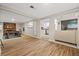 Open-concept living room featuring hardwood floors, brick fireplace and views of kitchen and additional living space at 1504 E Mcberry St, Tampa, FL 33610