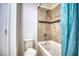 Clean bathroom with a shower/tub, tile surround, and teal shower curtain at 26888 Fiddlewood Loop, Wesley Chapel, FL 33544