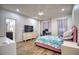 Bright bedroom with a pink bed, unicorn bedding, and built-in desk at 26888 Fiddlewood Loop, Wesley Chapel, FL 33544