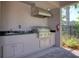 Outdoor kitchen area with grill, sink, and ample counter space at 26888 Fiddlewood Loop, Wesley Chapel, FL 33544