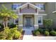 Inviting front entrance with a gray door and landscaping at 26888 Fiddlewood Loop, Wesley Chapel, FL 33544
