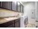 Laundry room with washer, dryer, cabinets, and a utility sink at 26888 Fiddlewood Loop, Wesley Chapel, FL 33544