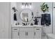 Modern bathroom with white vanity, round mirror, and gray accents at 3276 Sea Grape Dr, Hernando Beach, FL 34607