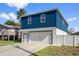 Two-story home with a blue exterior, white garage, and a landscaped yard at 3276 Sea Grape Dr, Hernando Beach, FL 34607