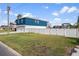 Two-story blue house with attached garage and fenced yard at 3276 Sea Grape Dr, Hernando Beach, FL 34607