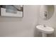 Small powder room with pedestal sink and round mirror at 5052 Captain Davis Dr, Wimauma, FL 33598