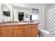 Bathroom with wood vanity, shower, and gray geometric curtain at 5956 Nyberg Rd, North Port, FL 34291