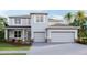 Two-story house with gray siding, two-car garage, and landscaping at 6843 Daintree Ct, Land O Lakes, FL 34638