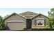 Gray house with stone accents, two-car garage, and landscaping at 7022 Broad River Ave, Land O Lakes, FL 34638