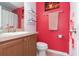 Clean bathroom with wood cabinets and a red accent wall at 9024 White Sage Loop # 37, Lakewood Ranch, FL 34202