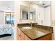 Bathroom with granite countertop, double sinks, and mirrors at 20040 Gulf Blvd # 605, Indian Shores, FL 33785