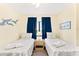 Two twin beds, dresser, and ceiling fan in a bright bedroom at 20040 Gulf Blvd # 605, Indian Shores, FL 33785