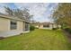 Private backyard with grassy area and partial view of neighboring home at 2620 Newcomb Ct, Sun City Center, FL 33573