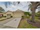 Front view of charming house with attached garage and well-manicured landscaping at 2620 Newcomb Ct, Sun City Center, FL 33573