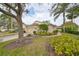 Side view of the house showcasing its attractive facade and lush landscaping at 2620 Newcomb Ct, Sun City Center, FL 33573