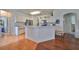 Open kitchen with breakfast bar, stainless steel appliances, and hardwood floors at 2620 Newcomb Ct, Sun City Center, FL 33573