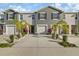 Two-story townhome with gray siding, two-car garage, and palm trees at 2920 Evergreen Elm Pass, Wesley Chapel, FL 33543