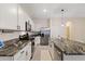 Modern kitchen with white cabinets, granite countertops, and stainless steel appliances at 2920 Evergreen Elm Pass, Wesley Chapel, FL 33543