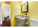 Bright bathroom with a gray vanity, a big mirror, and colorful yellow walls at 538 Southwest N Blvd, St Petersburg, FL 33703
