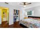 Bright bedroom with a ceiling fan, closet, and wood floors next to an open bathroom at 538 Southwest N Blvd, St Petersburg, FL 33703