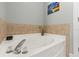 A close up of a bathtub with tile surround, a painting and faucet hardware at 6319 Sunset Bay Cir, Apollo Beach, FL 33572