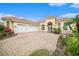 Grand home exterior featuring a three-car garage and brick driveway at 8478 Dunham Station Dr, Tampa, FL 33647