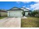 Light green house with a two-car garage and walkway to the front door at 939 Wynnmere Walk Ave, Ruskin, FL 33570