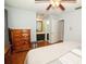 Spacious bedroom featuring hardwood floors, a connecting bathroom, and a large wooden dresser at 15625 Morning Dr, Lutz, FL 33559