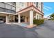 Condo building entrance with covered walkway and landscaping at 19029 Us Highway 19 N # 9-301, Clearwater, FL 33764