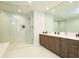Elegant bathroom with double vanity, a large mirror, and a walk-in shower at 301 1St S St # 804, St Petersburg, FL 33701