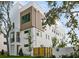 Modern architectural design with clean lines, mixed materials, and balconies, complemented by landscaped yard and privacy fence at 323 15Th N St, St Petersburg, FL 33705