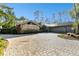 Long brick driveway leading to a beautiful home with stone accents and lush greenery at 5474 Kemkerry Rd, Wesley Chapel, FL 33543