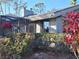 Close-up view of the home's exterior with screened in porch and lush foliage at 5474 Kemkerry Rd, Wesley Chapel, FL 33543