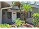 Inviting front entrance with tropical landscaping and a charming white door at 5474 Kemkerry Rd, Wesley Chapel, FL 33543