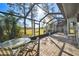 Screened-in patio features brick floors, metal framed enclosure, and a small outdoor table with chairs at 5474 Kemkerry Rd, Wesley Chapel, FL 33543