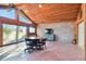 Sunroom with brick accent wall, wood ceiling, and sliding glass doors at 5474 Kemkerry Rd, Wesley Chapel, FL 33543