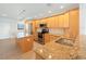 Bright kitchen with light wood cabinets, granite counters, and stainless steel appliances at 8701 Blind Pass Rd # 306B, St Pete Beach, FL 33706