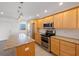 Bright kitchen with island, light wood cabinets, granite counters at 8701 Blind Pass Rd # 306B, St Pete Beach, FL 33706