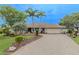 Charming single-story home featuring mature landscaping, a brick driveway, and an attached two-car garage at 1000 Chillum Ct, Safety Harbor, FL 34695