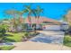 Charming home featuring a well-manicured front yard, palm trees, and a spacious driveway at 1000 Chillum Ct, Safety Harbor, FL 34695