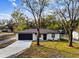 Modern single story home with a dark garage door and landscaped yard at 11650 County Road 579 Hwy, Thonotosassa, FL 33592